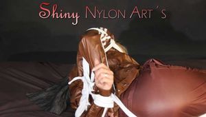 Watching sexy Sonja being tied and gagged on a bed with ropes and a clothgag wearing a supersexy shiny brown nylon pants and a brown rain jacket (Pics)