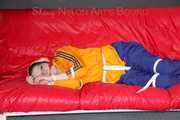 Lucy tied and gagged on a sofa wearing an orange shiny nylon rain jacket and a blue rain pants (Pics)