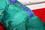Lucy putting on linen on bed wearing supersexy green shiny nylon rainwear (Pics)