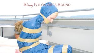 Beautiful archive girl in a blue shiny nylon rainsuit tied and gagged with tape on a sunlounger (Pics)