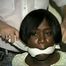 BLACK BANK TELLER IS MOUTH STUFFED, CLEAVE GAGGED & ROPE TIED TO CHAIR  (D46-2)