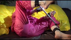 Sonja tied, gagged and hooded with a spreader bar on bed wearing a supersexy pink shiny nylon rainwear (Video)