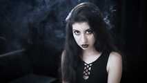 Goth girl with black eyes occasionally prefers dragging a 120mm cigarette