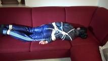 Lucy tied and gagged on a red sofa wearing a supersexy blue shiny nylon pants and a blue rain jacket (Video)