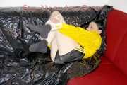 LUCY tied and gagged with ropes and a ballgag on a sofa wearing a sexy black/yellow shiny nylon shorts and a yellow rain jacket (Pics)