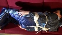 Lucy tied and gagged on a red sofa wearing a supersexy blue shiny nylon pants and a blue rain jacket (Video)
