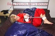 Pia tied and gagged on bed wearing a shiny red rain pants and a shiny red/purple down jacket (Pics)