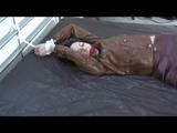 Simone tied and gagged on bed wearing a brown shiny nylon rainjacket and a rainpants (Video)