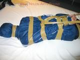 One of our archive girls bound and gagged in a blue shiny rainsuit 