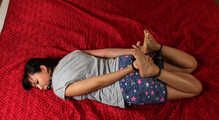 Ballgegged barefoot Lois in t-shirt and shorts, hog-cuffed on the floor with hinged cuffs, wiggles helplessly