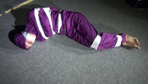 Sexy Sandra wearing a supersexy purple shiny nylon rainsuit bein tied and gagged and hooded on the floor with tape (Video)