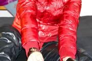 Pia tied and gagged with a bar on bed wearing a supershiny black down pants and a red down jacket (Pics)