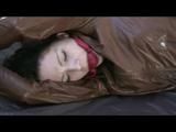 Simone tied and gagged on bed wearing a brown shiny nylon rainjacket and a rainpants (Video)