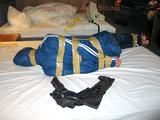 One of our archive girls bound and gagged in a blue shiny rainsuit 