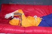Lucy tied and gagged on a sofa wearing an orange shiny nylon rain jacket and a blue rain pants (Pics)
