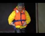Sexy Mara trying on her new yellow down jacket and her lifevest in combination with a sexy shiny black rain pants and rubber boots (Video)
