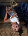 Barefoot Christy in white t-shirt and jeans shorts, suspended sideways, is being played with camera man