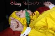 Watching sexy Pia being tied and gagged with ropes on a bed and a clothgag wearing sexy yellow shiny nylon rainwear (Pics)