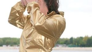 Enni posing outdoor on a lake wearing a supersexy blue shiny nylon rain pants and a golden rain jacket (Pics)