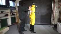 Watch Lady M bound in a yellow Rainsuit wearing a latex Hood and a Gasmask