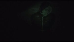 Jill tied, gagged and hooded on a cellar floor wearing a shiny green rain pants and a shiny black down jacket (Video)