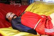 Watching sexy Jill being tied and gagged with ropes and a ballgag on a bed wearing a sexy red shiny nylon shorts and an oldschool rain jacket (Pics)