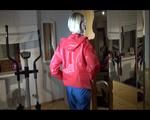 Watch Sonja to dress herself with rainwear and begin her workout on the home trainer (Video)