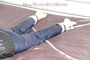 Shelly tied and gagged on a bed with downjacket and shiny rainsuit