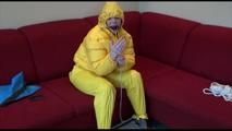 Jill ties, gagges and hoodes herself wearing a shiny yellow down jacket and a yellow rain pants(Video)