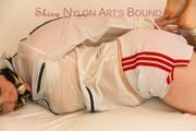 JIll tied and gagged on a white sofa wearing a sexy white/red shiny nylon shorts and a white rain jacket (Pics)