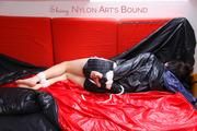 Simone tied and gagged in a big shiny nylon bag to lie in wearing a black shiny nylon shorts and a black shiny nylon rainjacket (Pics)