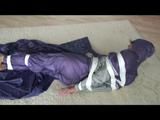 A video with Alina tied and gagged in a shiny purple and silver PVC suit