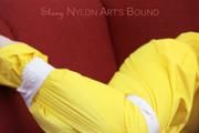 Mara tied, gagged and hooded with tape on a red sofa wearing shiny yellow rainwear (Pics)