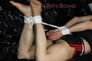 Sandra wearing a sexy black/red shiny nylon shorts and a black top being tied and gagged with ropes on a sofa (Pics)