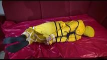 Lucy tied, gagged and hooded on a sofa with dark ropes wearing a sexy yellow rainwear combination (Video)