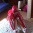Black haired archive girl tied, gagged and hooded on the floor wearing a shiny red nylon shorts and a shiny red rain jacket (Video)