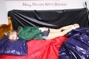 Samantha tied and gagged in bed wearing a black shiny nylon shorts and a green rainjacket (Pics)