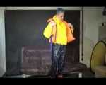 Sexy Mara trying on her new yellow down jacket and her lifevest in combination with a sexy shiny black rain pants and rubber boots (Video)
