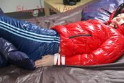 Mara tied and gagged on bed wearing a sexy shiny red down jacket and a blue rain pants (Pics)