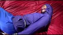 Sonja tied and gagged with ropes and a ballgag on a bed covered with a red shiny nylon cloth wearing a blue shiny nylon rain pants and a purple rain jacket (Video)