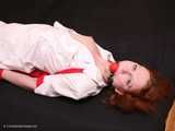 Barefoot nurse Gatitta tied up with a red rope