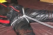 Lucy tied and gagged in a bed wearing a black shiny nylon downwear combination (Pics)