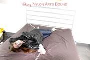 Shelly tied and gagged on a bed with downjacket and shiny rainsuit