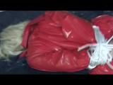 A video with Nina tied and gagged in a shiny PVC suit