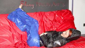 Sonja wearing a blue shiny nylon raver pants and a black down jacket posing and lollingn on the sofa (Pics)