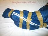 One of our archive girls bound and gagged in a blue shiny rainsuit 