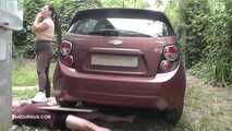Mistress Jenna stands on the slave with a car while smoking in the slave's mouth A