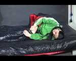 Lucy wearing a green shiny nylon shorts and a green rain jacket lolling on bed (Video)