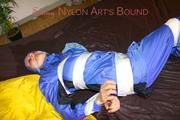 Lucy taped, hooded and gagged on bed wearing sexy blue rainwear (Pics)