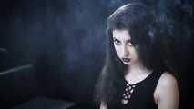 Goth girl with black eyes occasionally prefers dragging a 120mm cigarette
